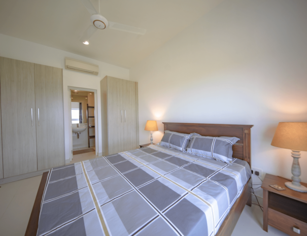 Galle Luxury Apartment Accommodations A spacious and luxurious master bedroom showcasing a comfortable queen-size bed, elegant built-in robes, and a modern ensuite bathroom with a spacious shower and high-end fixtures.