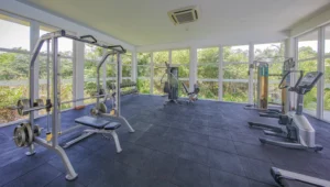 Modern gym at Aganthuka Galle equipped with treadmills and workout benches. This fitness facility offers a range of exercise equipment for guests looking to maintain their fitness routine during their stay, in a clean and well-organized space.